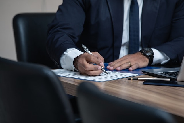 Man in suit signing a document